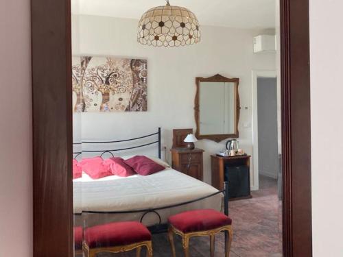 a bedroom with a bed with red pillows and a mirror at Sacripante in Ostellato