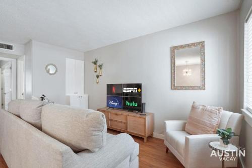 a living room with a couch and a tv at Cook and Gather Around in a Fully Equipped Apartment in Austin