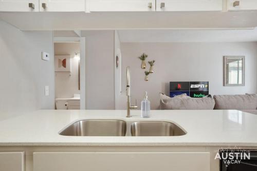 a kitchen with a sink and a white counter top at Cook and Gather Around in a Fully Equipped Apartment in Austin