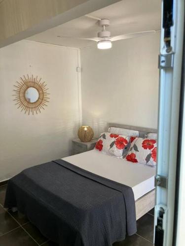 1 dormitorio con cama y espejo en la pared en Tilys lodge, en Capesterre-Belle-Eau
