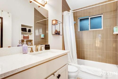 La salle de bains est pourvue d'un lavabo, de toilettes et d'une douche. dans l'établissement Quick Bike Ride to Central Austin from Quiet 1BD, à Austin
