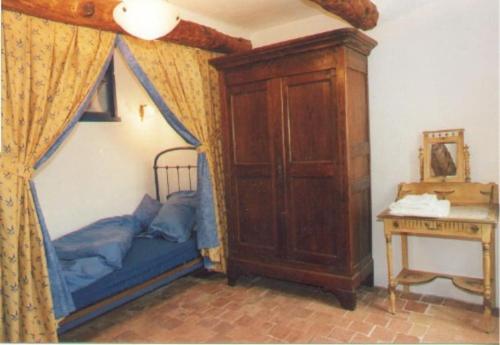 a bedroom with a canopy bed and a table at La Placette - votre maison en pierres authentique in Bizanet