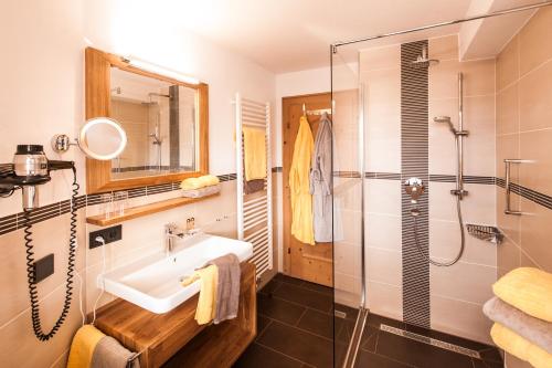 a bathroom with a sink and a shower at Hotel Rubihaus in Oberstdorf