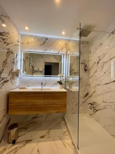 une salle de bain avec un lavabo et un miroir dans l'établissement Le Concorde, à Aix-en-Provence