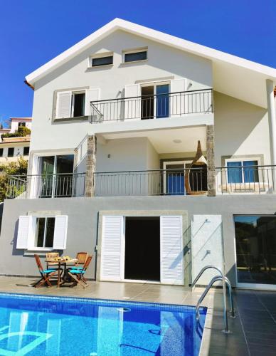 a villa with a swimming pool in front of a house at Villa Fanny in Ribeira Brava