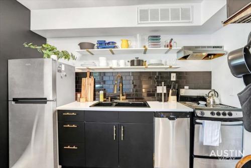 a kitchen with black cabinets and a stainless steel refrigerator at Cool Down On Riverside Free Parking and Shared Pool in Austin