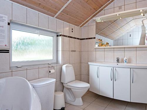a bathroom with a toilet and a sink and a window at 8 person holiday home in Oksbøl-By Traum in Oksbøl