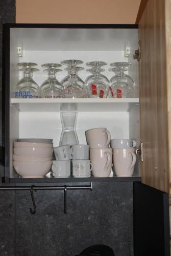 a shelf with a bunch of cups and glass jars at Café du Pêcheurs in Bouillon
