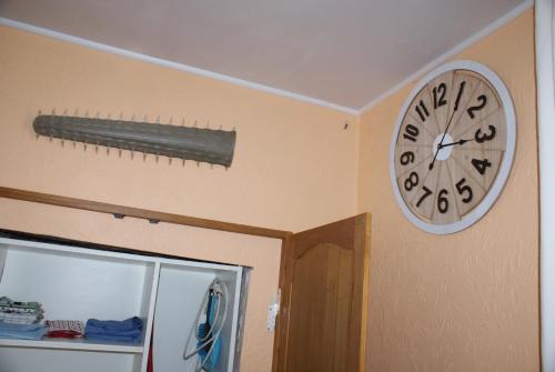 a clock hanging on a wall next to a door at Café du Pêcheurs in Bouillon