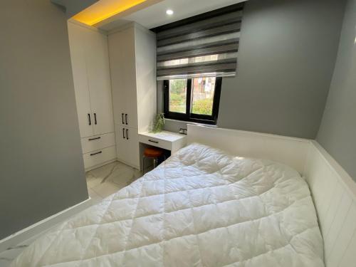 - une chambre avec un lit blanc et une fenêtre dans l'établissement Antalya lara suite more, à Antalya