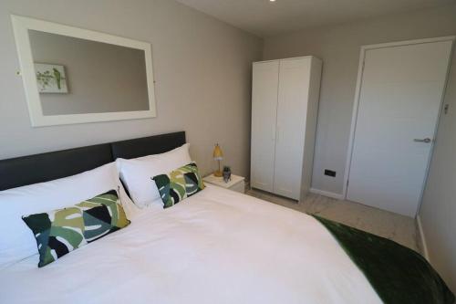 una camera da letto con un grande letto bianco con due cuscini di Welcoming 2 Bedroom Home with Driveway Parking a Morecambe