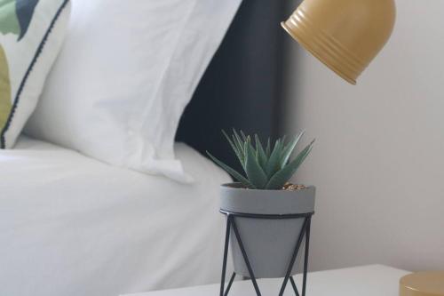 una pianta in vaso seduta su un tavolo accanto a un letto di Welcoming 2 Bedroom Home with Driveway Parking a Morecambe