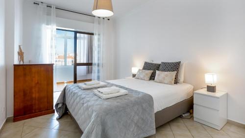 a bedroom with a bed with two towels on it at Sun-kissed Oasis W/ Pool by LovelyStay in Albufeira