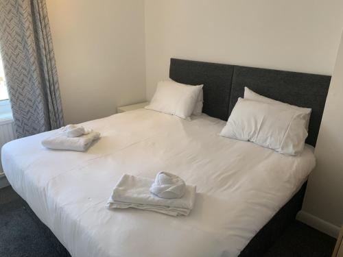 duże białe łóżko z dwoma ręcznikami w obiekcie Ratcliffe House - Spacious 3 bedroom House in Sileby w mieście Sileby