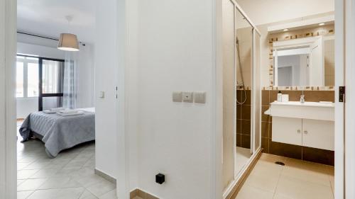 a bathroom with a sink and a bed in a room at Sun-kissed Oasis W/ Pool by LovelyStay in Albufeira