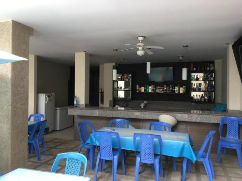 Hotel Dorado Inn في ساليناس: غرفة طعام مع طاولة زرقاء وكراسي زرقاء