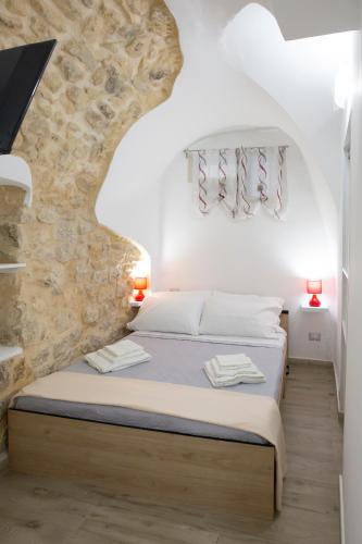 a bedroom with a bed in a stone wall at L'arco sul fiume in Scicli