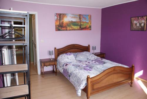 - une chambre avec un lit et un mur violet dans l'établissement Café du Pêcheurs, à Bouillon