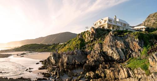 a house on a cliff next to a beach at Birkenhead House in Hermanus