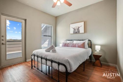 a bedroom with a bed with a ceiling fan and a window at Balcony Views and Ideal West Campus Austin Location in Austin
