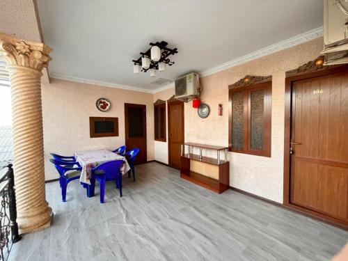 um quarto com uma mesa e cadeiras e uma coluna em Hamida em Samarkand