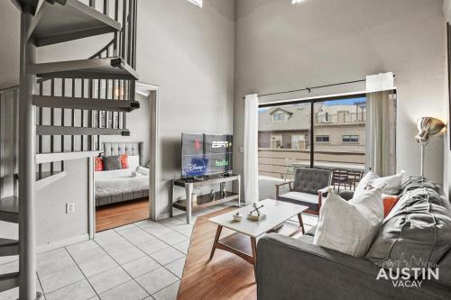 a living room with a couch and a table and a tv at King Beds and Patio Dining in ATX West Campus Gem in Austin