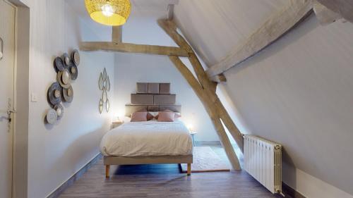 a bedroom with a bed in a attic at Demeure du Vallon - Chambres d'Hôtes de Charme in Azerat