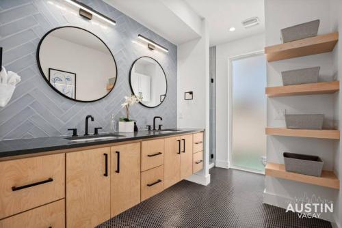 a bathroom with two sinks and a large mirror at Modern Luxury Home - Minutes from Lady Bird Lake in Austin