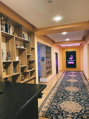 a large room with a library with shelves and a television at Flamingo in Dushanbe