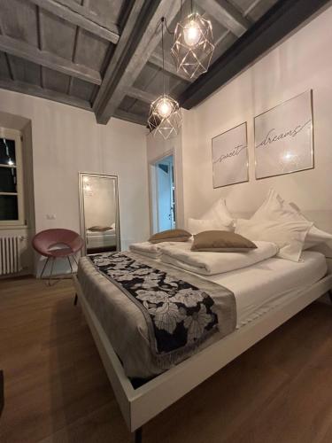 a bedroom with a large bed and a chandelier at Sweet Dreams in Cannobio
