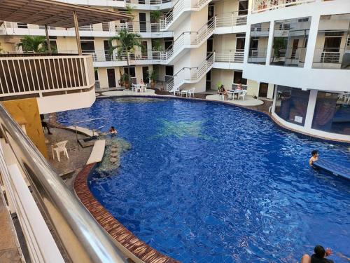 a large swimming pool in the middle of a building at Sheryll Escapes - Kandi Palace Posh 9th floor new studio with King bed and housekeeping in Angeles