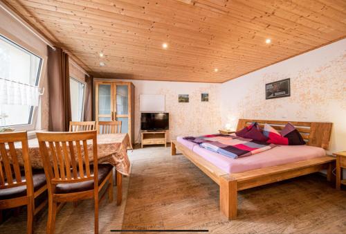 a bedroom with a bed and a table and chairs at Toskanahaus, NJUALMS in Tannheim