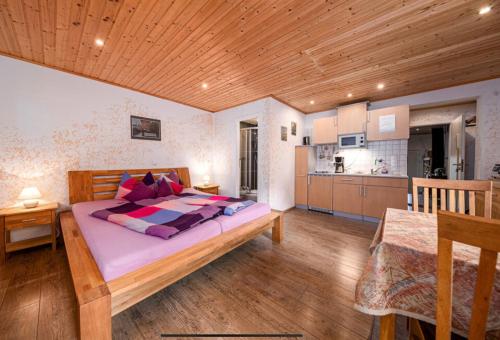 a bedroom with a large bed and a kitchen at Toskanahaus, NJUALMS in Tannheim
