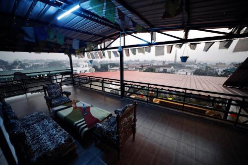 a balcony with two chairs and a table on a ship at The Location, A Penthouse in Dehradun