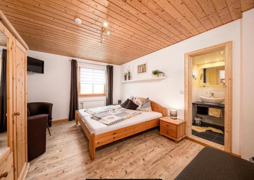 a bedroom with a bed and a sink in it at Toskanahaus, NJUALMS in Tannheim