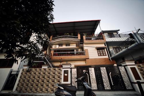 a house with a scooter parked in front of it at The Location, A Penthouse in Dehradun