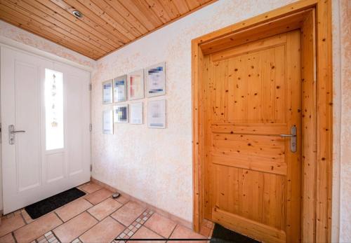 a wooden door in a room with a tile floor at Toskanahaus, NJUALMS in Tannheim