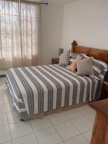 Schlafzimmer mit einem Bett mit einer schwarz-weißen gestreiften Bettdecke in der Unterkunft Seacastles in Montego Bay