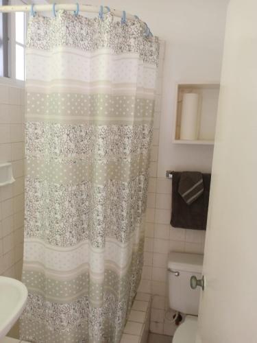 ein Bad mit einem Duschvorhang und einem WC in der Unterkunft Seacastles in Montego Bay