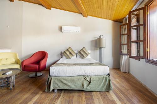 a bedroom with a bed and a red chair at Mesmerizing Flat near Hadrians Gate in Antalya