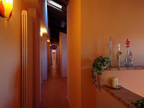 a hallway with orange walls and a long corridor at Antica Grancia Benedettina in Colorno