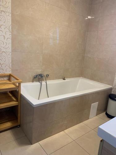 a bathroom with a white tub in a room at Hilltop Apartments in Fonyód