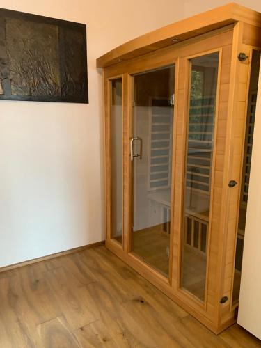 a wooden cabinet with glass doors in a room at Hilltop Apartments in Fonyód