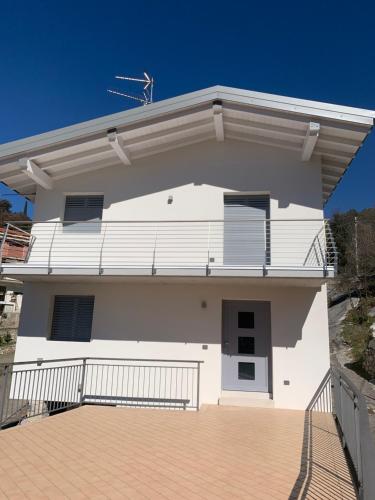 a white house with a balcony on top of it at Appartamento Gardenia in Malcesine