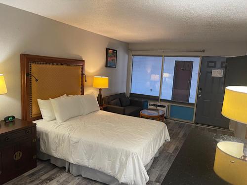 a hotel room with a bed and a chair at Branson Ozarks Inn in Branson