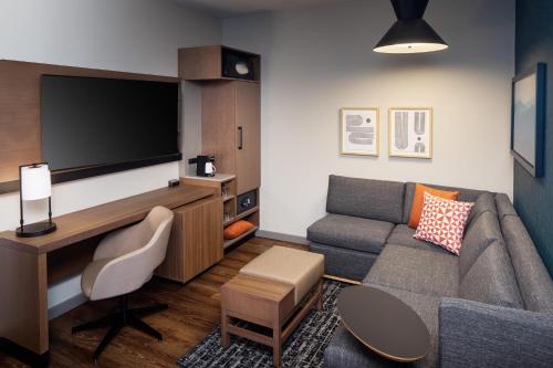 a living room with a couch and a flat screen tv at Hyatt Place Harrisonburg in Harrisonburg