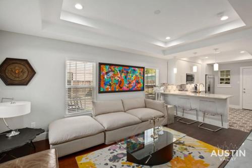 a living room with a couch and a kitchen at Walk to UT and E 6th in ATX House and Free Swim Club by Austin Vacay in Austin