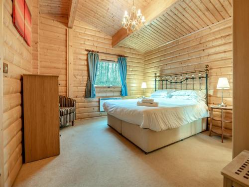 LegbourneにあるForest Lodgeの木製の壁のベッドルーム1室(ベッド1台付)