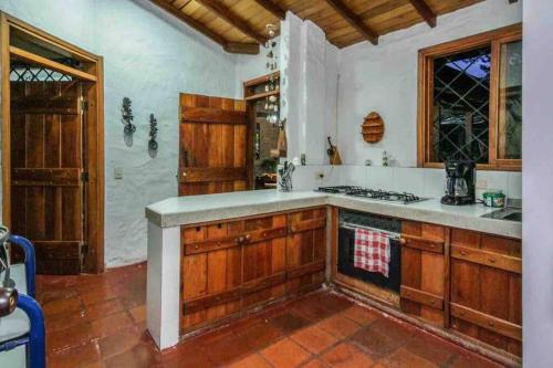 La cuisine est équipée de placards en bois et d'un four avec plaques de cuisson. dans l'établissement Finca Punta de Piedra Salento, Quindio, à Salento