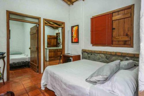 - une chambre avec un grand lit blanc dans l'établissement Finca Punta de Piedra Salento, Quindio, à Salento